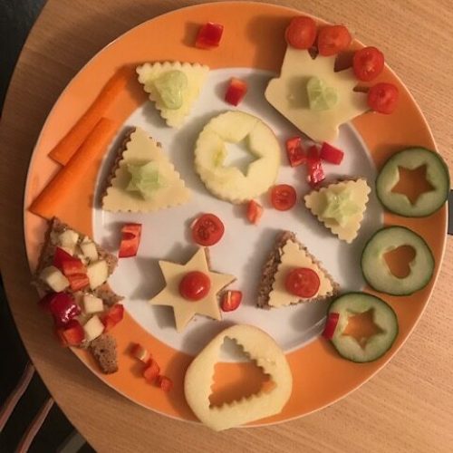 Käsebrote und Gurken mit Weihnachts-Ausstechern bearbeitet und Tomaten dekoriert